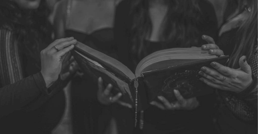This image of witches holding a spellbook illustrates our discussiont topic: Bionic infringers, and keeping brands safe from cyberattacks during spooky season.