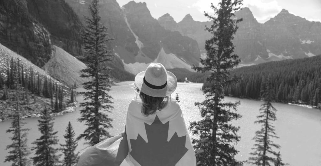 This image of someone wrapped in the Canadian flag in front of a beautiful mountainous panorama highlights our discussion topic: counterfeiting and replicas in Canada, what brands can learn about them, and how to fight back.