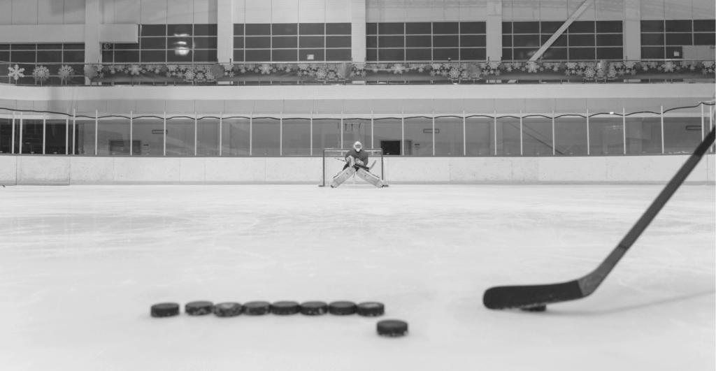 This image of a distant ice hockey goalkeeper and a closeup set of pucks for a penalty shootout our discussion topic: counterfeiting and replicas in Canada, what brands can learn about them, and how to fight back.