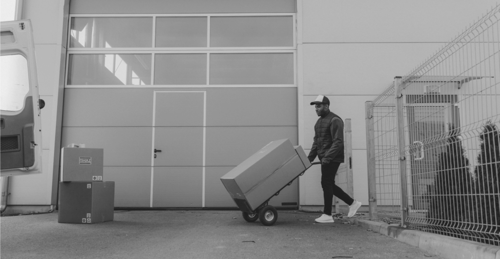 This image of a man delivering parcels on a dolly from a warehouse illustrates this discussion topic: A counterfeits definition, and what it means for brands in the fight agains counterfeiting.