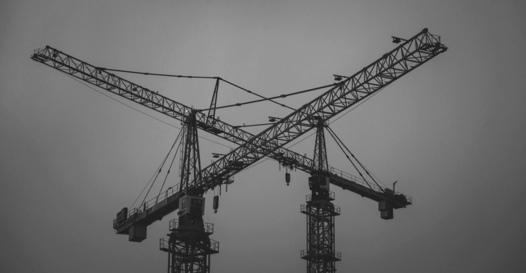 This image of two cranes crossing over in construction illustrates our discussion topic: Exploring the best ways to build stable, secure, forward-thinking DNS infrastructure.