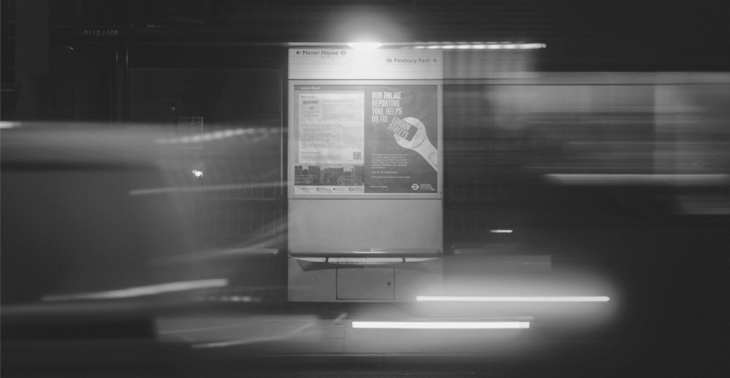 This image of an advertisement hoarding at a bus stop at night illustrates our discussion topic: Fake and infringing ads, and PPC brand protection solutions.