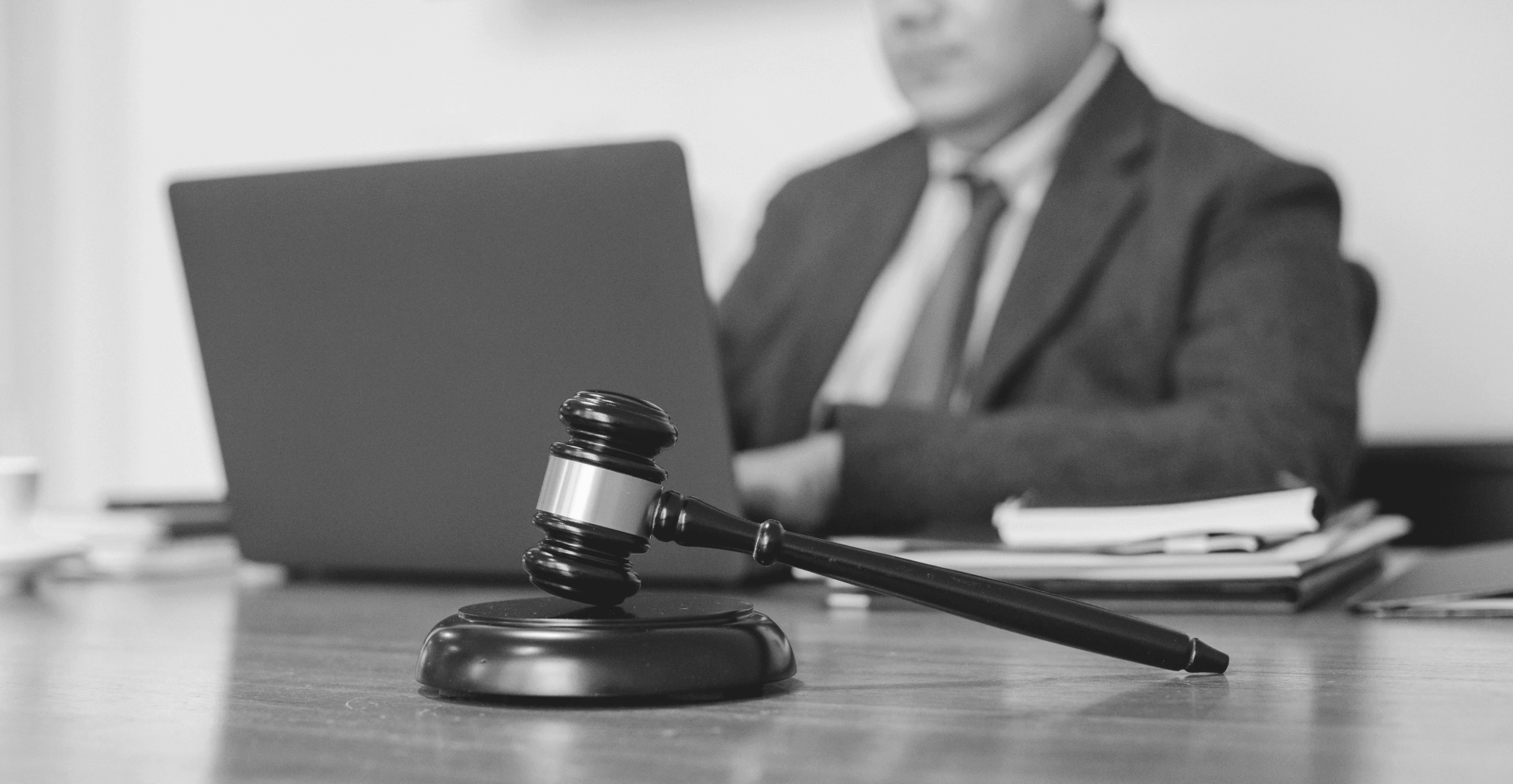 This image of a man at a desk with a computer and a gavel illustrates our discussion topic: domain names vs. trademarks