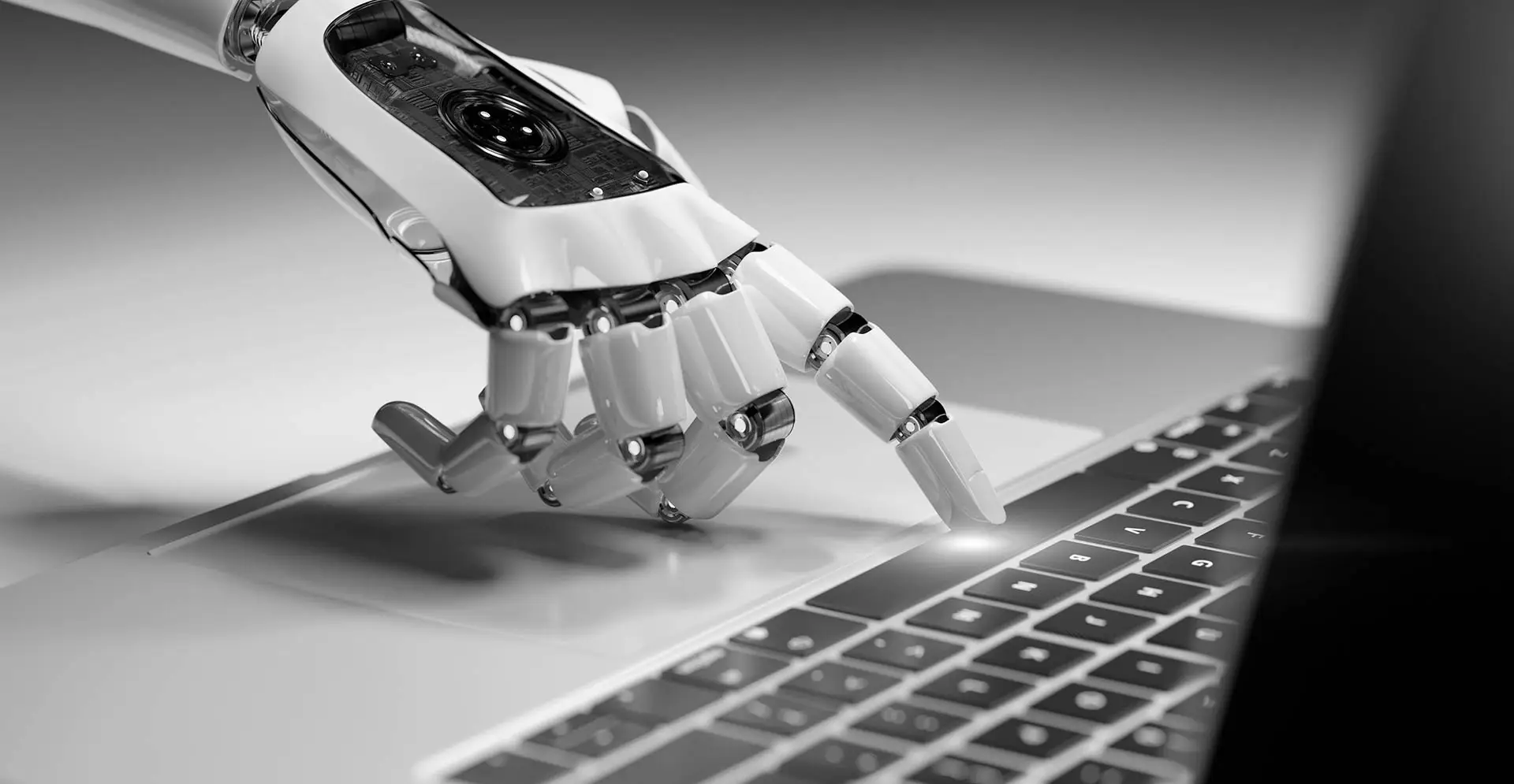 Robotic hand interacting with a laptop keyboard, symbolizing artificial intelligence and automation in digital technology